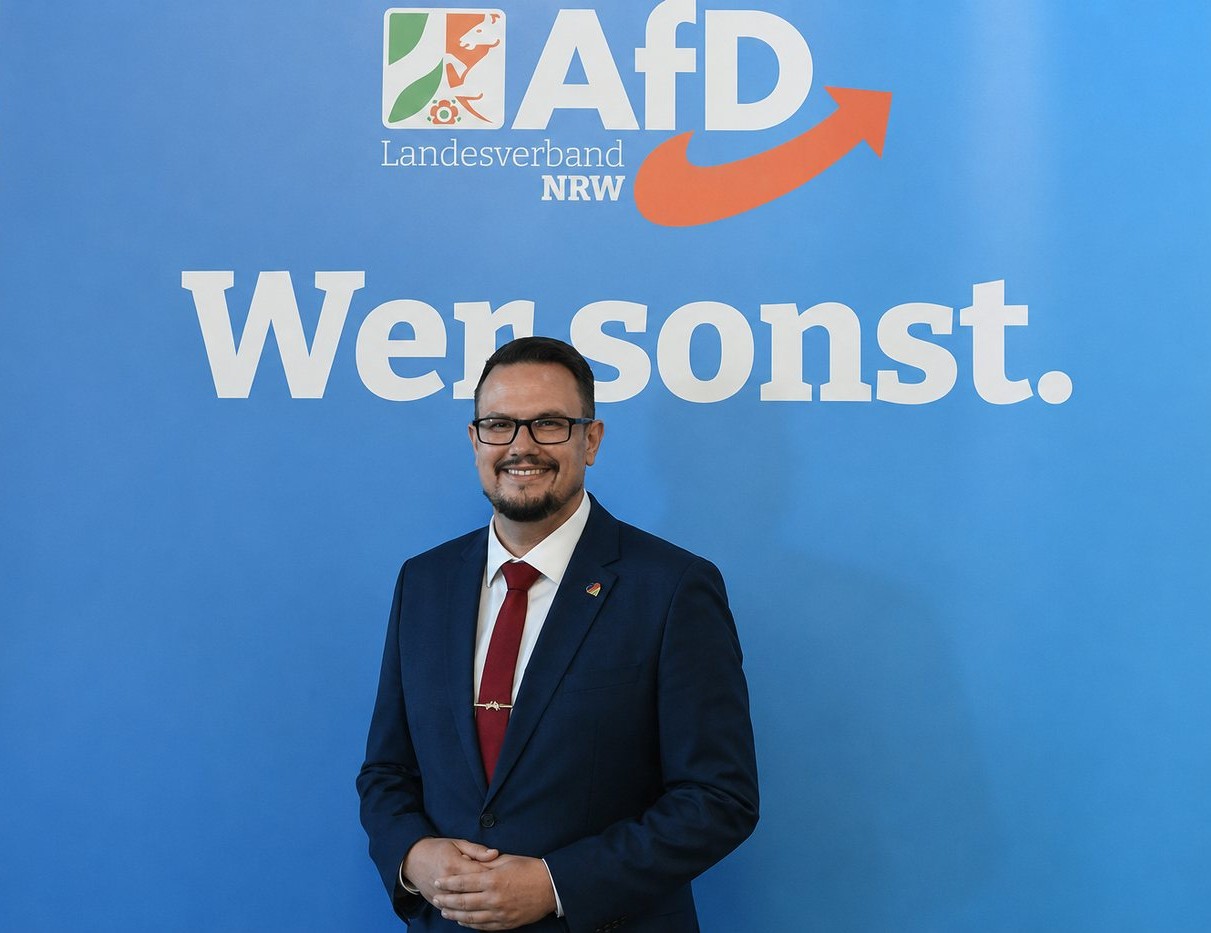 Kevin Burmeister vor der Wand „Wer sonst.“ des AfD-Landesverbands NRW